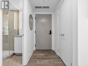 Toronto (Leaside) condo for rent - A hallway with a white door and a mirror on the wall.