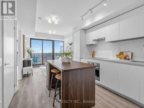 Toronto (Leaside) condo for rent - A modern kitchen with a wooden island and white cabinets.