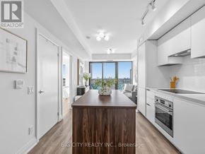 Toronto (Leaside) condo for rent - A modern kitchen with white cabinets and a wooden island.