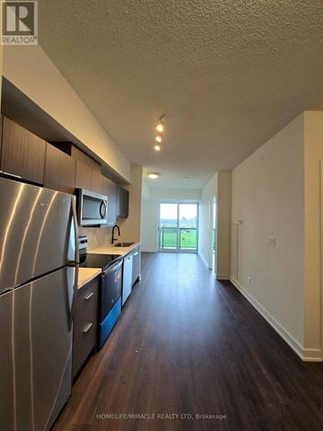 Toronto (Glenfield-Jane Heights) condo for rent - A kitchen with stainless steel appliances and wooden floors.
