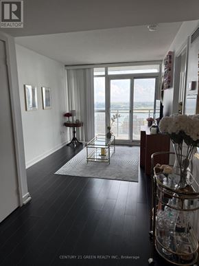 Toronto (Waterfront Communities) condo for rent - A hallway with a glass table and a vase of flowers.