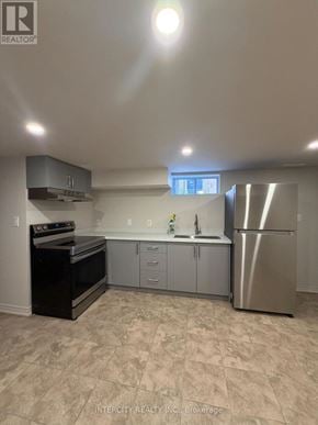 Toronto (Oakwood Village) apartment for rent - A kitchen with a black oven and a stainless steel refrigerator.