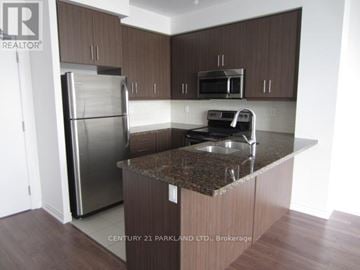 Toronto (Downsview-Roding-Cfb) condo for rent - A kitchen with brown cabinets and a granite countertop.