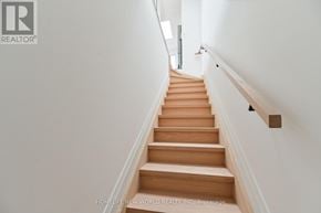 Toronto (Dovercourt-Wallace Emerson-Junction) townhouse for rent - A staircase with wooden steps and a handrail.