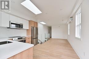 Toronto (Dovercourt-Wallace Emerson-Junction) townhouse for rent - A kitchen with white cabinets and a wooden floor.