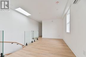 Toronto (Dovercourt-Wallace Emerson-Junction) townhouse for rent - A spacious room with wooden flooring and white walls.