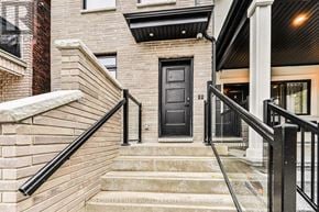 Toronto (Dovercourt-Wallace Emerson-Junction) townhouse for rent - A black door is on the front of a brick house.