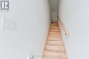 Toronto (Dovercourt-Wallace Emerson-Junction) townhouse for rent - A long hallway with wooden stairs leading to a door at the end.