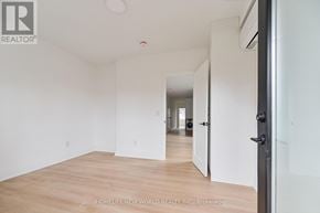 Toronto (Dovercourt-Wallace Emerson-Junction) townhouse for rent - A room with wooden flooring and white walls, with a door on the right side.