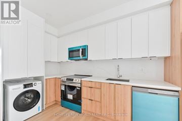 Toronto (Dovercourt-Wallace Emerson-Junction) townhouse for rent - A kitchen with white cabinets and a blue dishwasher.