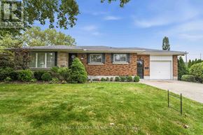 St. Catharines (Bunting/Linwell) apartment for rent - A house with a brick facade and a white garage door.