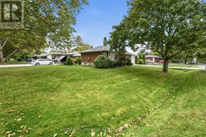 St. Catharines (Bunting/Linwell) apartment for rent - A well-maintained lawn with a house and trees in the background.