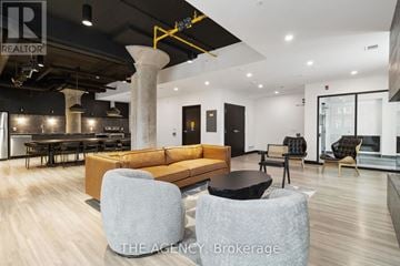 Guelph (St. Patrick's Ward) condo for rent - A modern living room with a large sectional sofa and a black coffee table.
