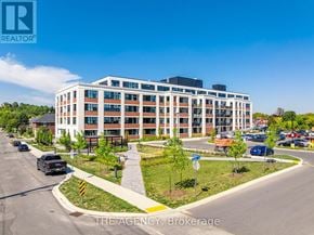 Guelph (St. Patrick's Ward) condo for rent - A large white building with a parking lot in front of it.