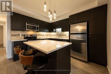 Kitchener townhouse for rent - A modern kitchen with a stainless steel refrigerator and a center island.