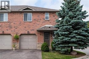 Stoney Creek townhouse for rent - A red brick house with a grey garage door.