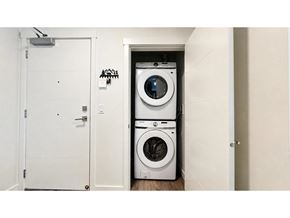 Langley apartment for rent - A white door is open to a small laundry room with a washer and dryer stacked on top of each other.
