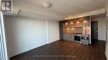 Mississauga (City Centre) condo for rent - A spacious living room with a kitchenette in the background.