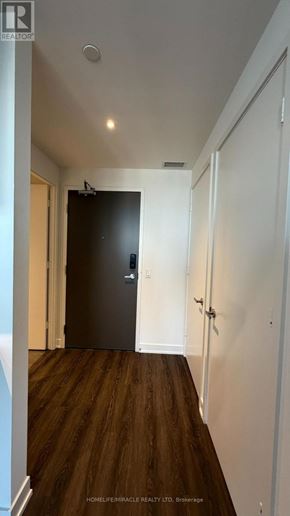 Mississauga (City Centre) condo for rent - A hallway with a black door and wooden floors.