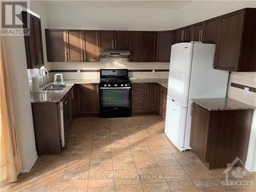 Ottawa apartment for rent - A kitchen with brown cabinets and a white refrigerator.