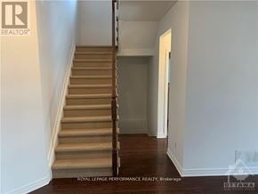 Ottawa apartment for rent - A staircase with a beige carpeted runner and white walls.