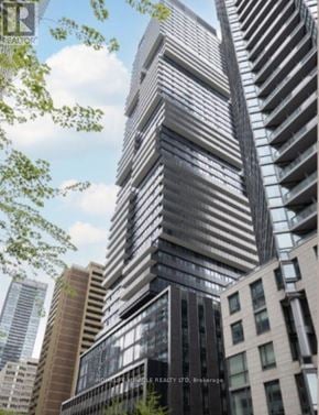 Toronto (Church-Yonge Corridor) condo for rent - A tall building with a modern design stands in front of other buildings.