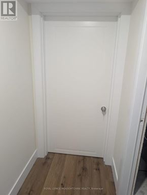 London South (South Y) apartment for rent - A white door with a silver handle is in a room with wooden flooring.
