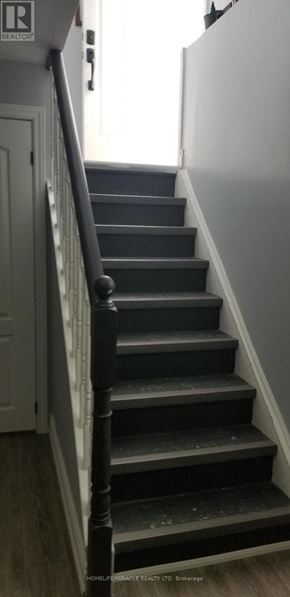 Barrie (Allandale) apartment for rent - A staircase with a black railing and grey steps.