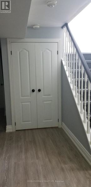 Barrie (Allandale) apartment for rent - A white door with a black handle is in a room with wooden flooring.