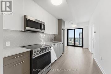 Kitchener condo for rent - A modern kitchen with a stainless steel microwave above the stove.