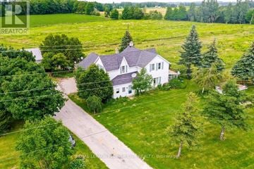 Melancthon apartment for rent - A white house with a grey roof is surrounded by green trees.