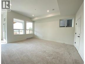 Maple Ridge apartment for rent - A spacious room with a carpeted floor and a window with blinds.