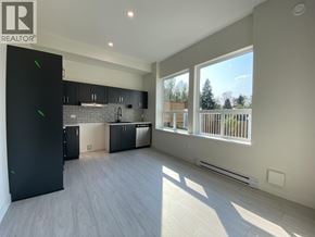 Maple Ridge apartment for rent - A spacious kitchen with black cabinets and a refrigerator.
