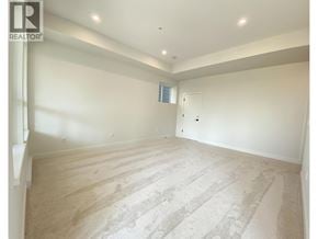 Maple Ridge apartment for rent - A spacious room with a carpeted floor and a door in the background.