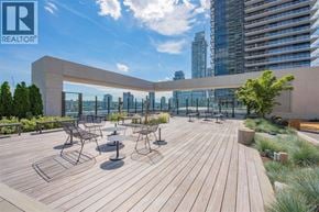 Burnaby apartment for rent - A wooden deck with chairs and tables overlooking a city skyline.