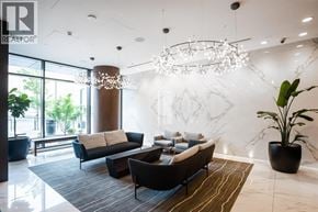 Burnaby apartment for rent - A modern living room with a large chandelier and a marble wall.