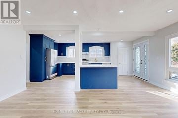 Oshawa (Eastdale) apartment for rent - A spacious kitchen with blue cabinets and a central island.