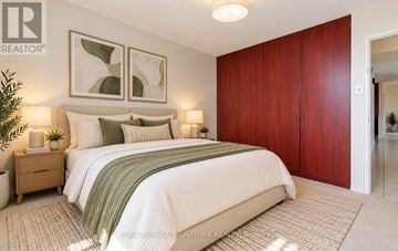 Brampton (Queen Street Corridor) condo for rent - A bedroom with a large bed, two nightstands, and a plant.
