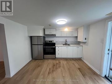 Cambridge apartment for rent - A kitchen with white cabinets and a wooden floor.