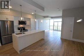 Niagara Falls (Oldfield) condo for rent - A kitchen with a refrigerator, sink, and cabinets.