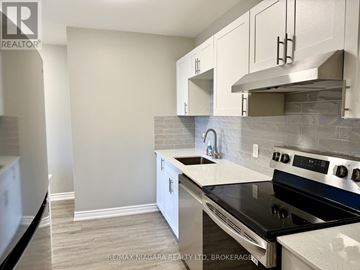 Niagara Falls (Stamford) apartment for rent - A kitchen with a stove top oven and white cabinets.