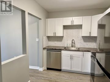 Niagara Falls (Stamford) apartment for rent - A kitchen with white cabinets and a marble backsplash.