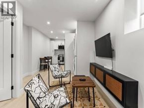 Vancouver apartment for rent - A living room with a black and white sofa set and a television mounted on the wall.