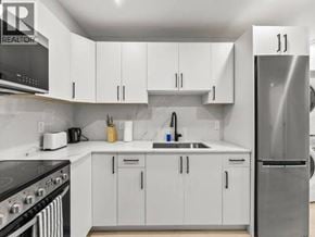 Vancouver apartment for rent - A kitchen with white cabinets and a stainless steel refrigerator.