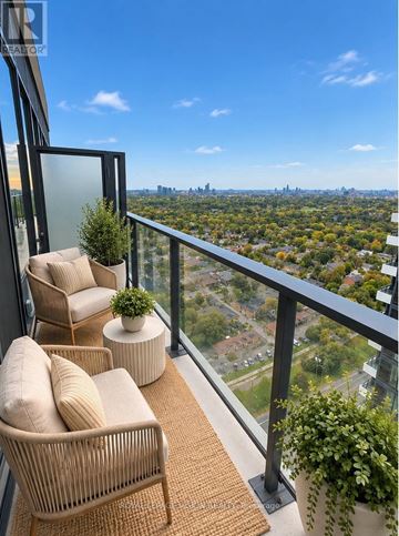 Toronto (Humber Heights) condo for rent - A balcony with a chair and a table with a potted plant on it.