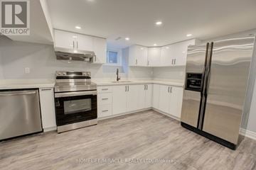 Toronto (Mount Olive-Silverstone-Jamestown) apartment for rent - A modern kitchen with white cabinets and stainless steel appliances.