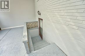 Toronto (Mount Olive-Silverstone-Jamestown) apartment for rent - A staircase with a wooden handrail and a decorative tile on the wall.