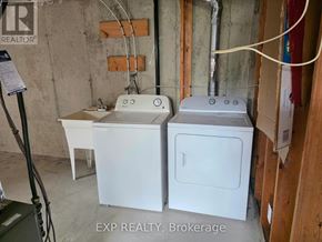 Kitchener townhouse for rent - A white washer and dryer are sitting next to each other in a basement.