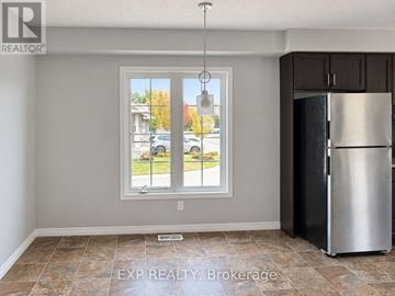 Kitchener townhouse for rent - A kitchen with a refrigerator and a window overlooking a street.