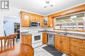 Welland (Dain City) apartment for rent - A kitchen with wooden cabinets and a white stove top oven.